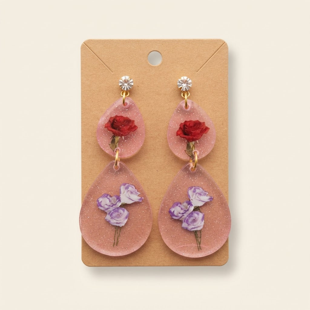 Boucles d’oreilles roses fleuries en résine sur fond studio
