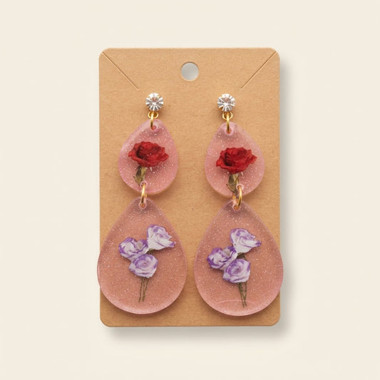 Boucles d’oreilles roses fleuries en résine sur fond studio