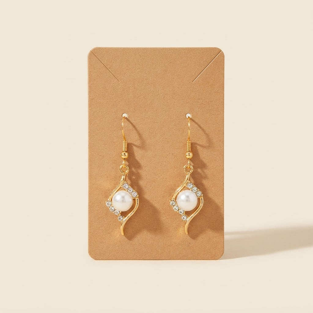 Boucles d’oreilles dorées perle et strass vue alternative sur fond studio