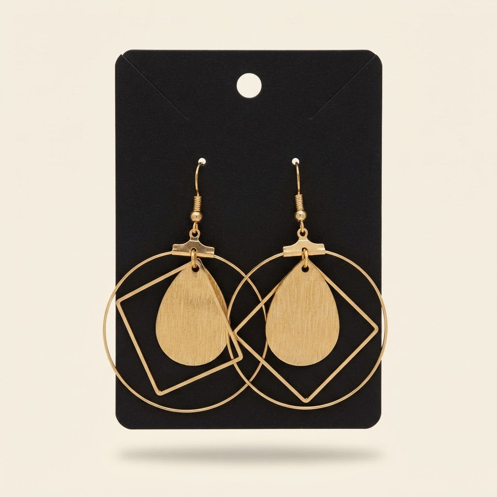 Boucles d’oreilles géométriques dorées à goutte effet bois sur fond studio