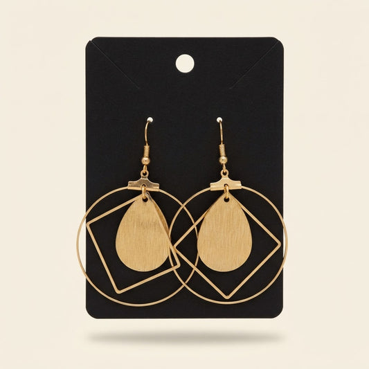 Boucles d’oreilles géométriques dorées à goutte effet bois sur fond studio