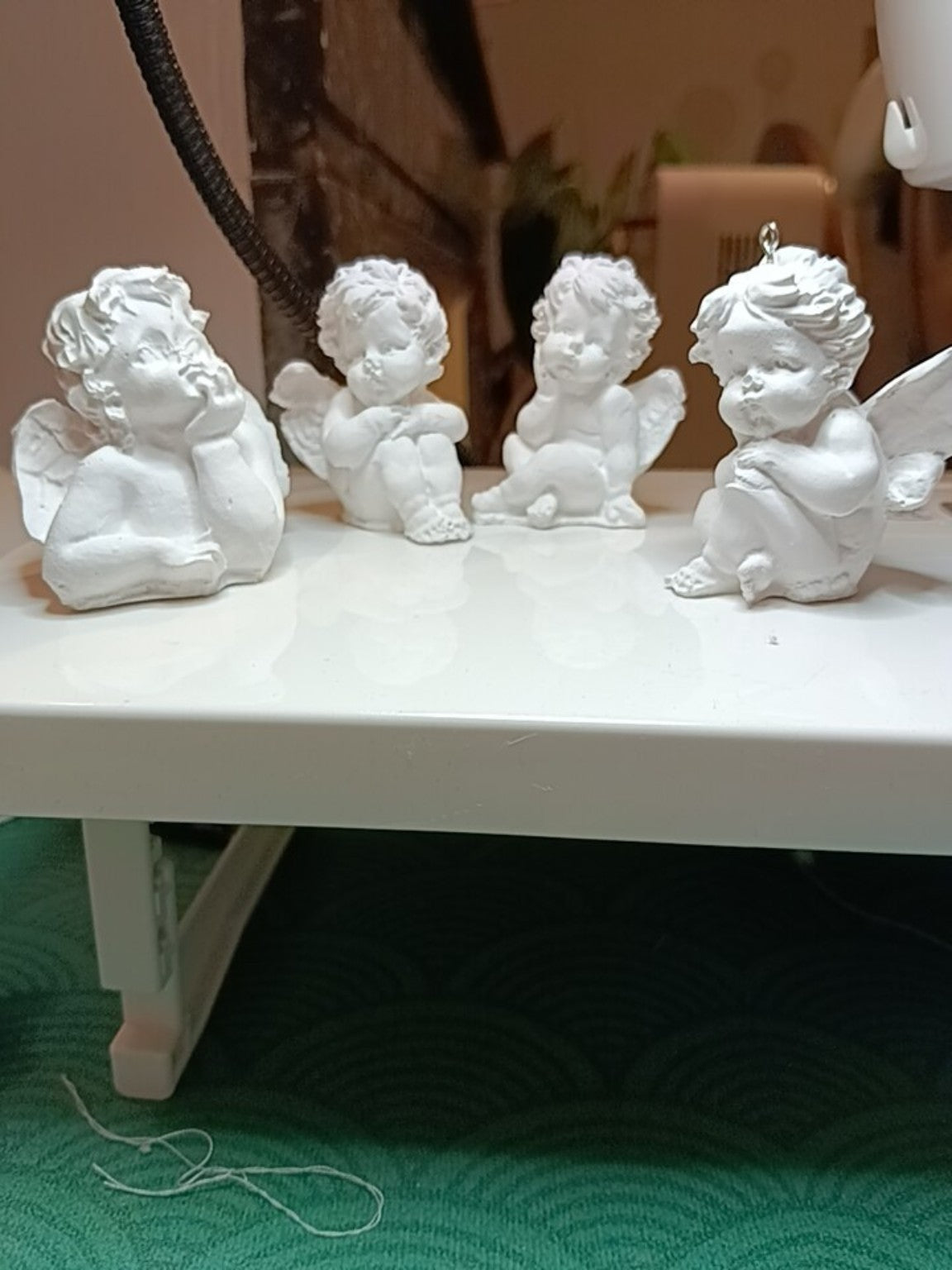 Lot de quatre petits anges décoratifs en jesmonite