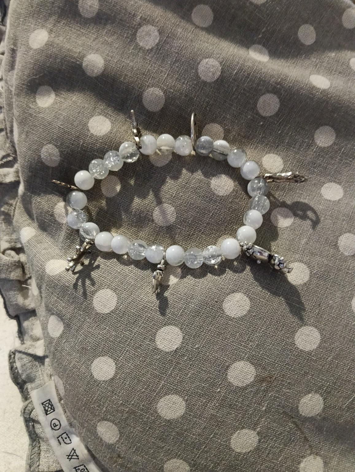 Bracelet blanc et transparent à breloques argentées