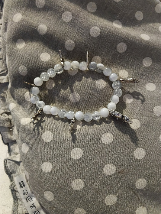 Bracelet blanc et transparent à breloques argentées