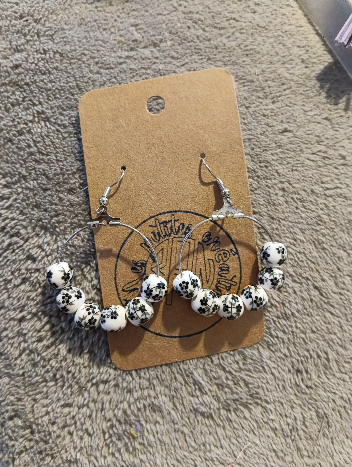 Boucles d’oreilles créoles à perles blanches motif fleurs noires