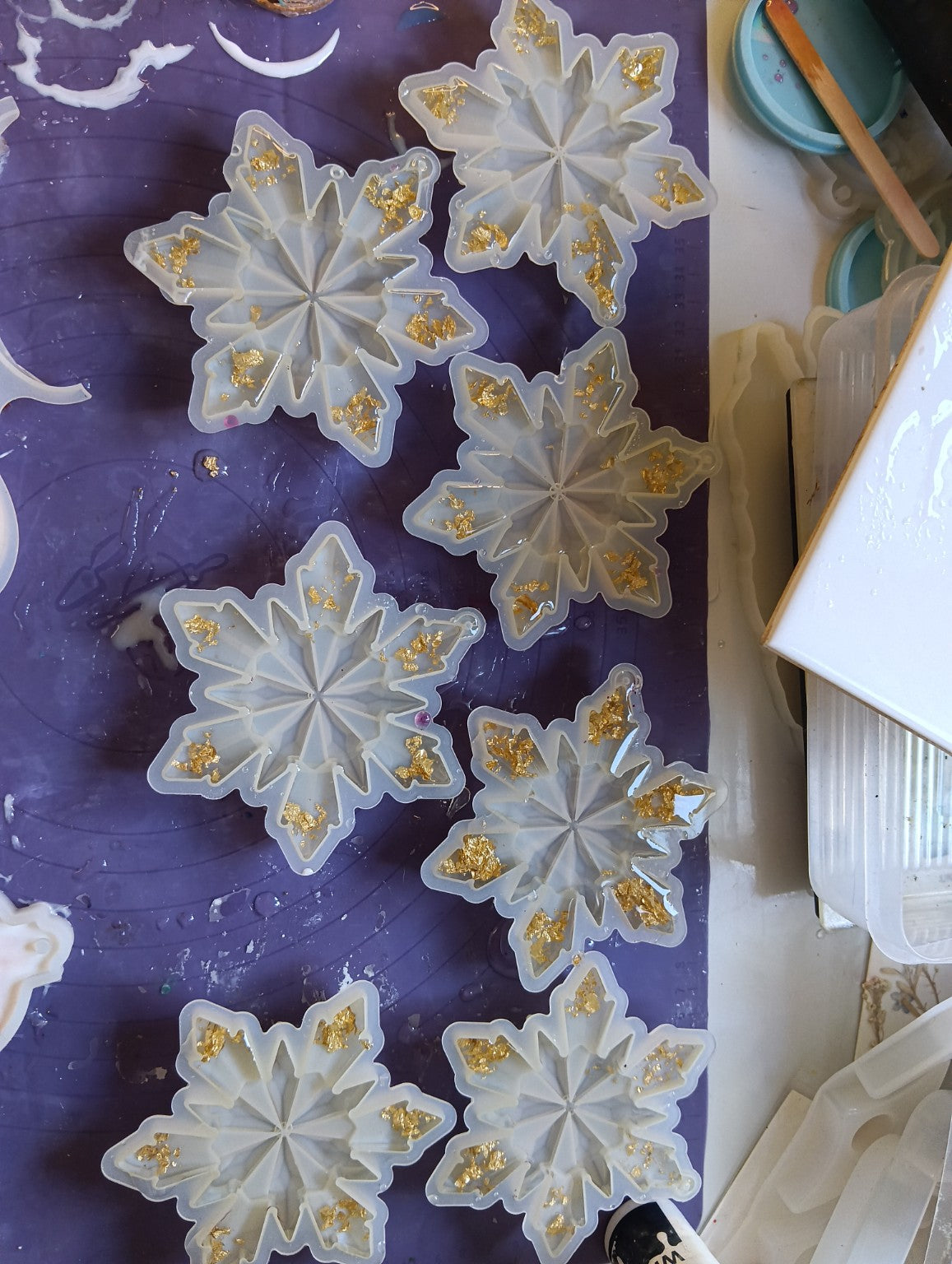 Fabrication de la collection Éclats d’Or : flocons en résine transparente avec feuilles dorées dans les moules