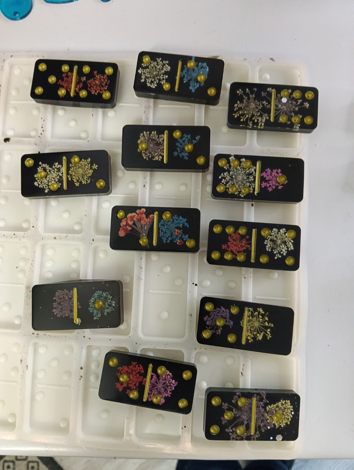 Jeu de dominos artisanal en résine noire avec fleurs séchées et détails dorés