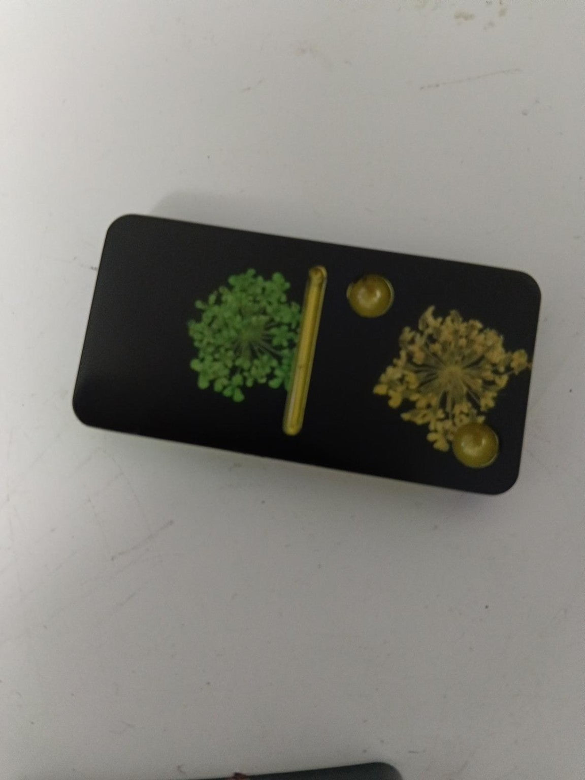 Gros plan d'un domino en résine noire avec fleurs et détails dorés