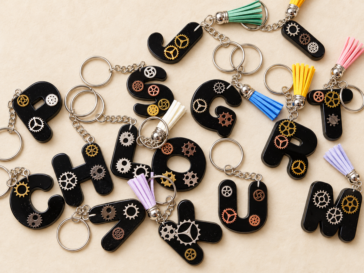 Assortiment de porte-clés lettres artisanaux en résine noire avec engrenages