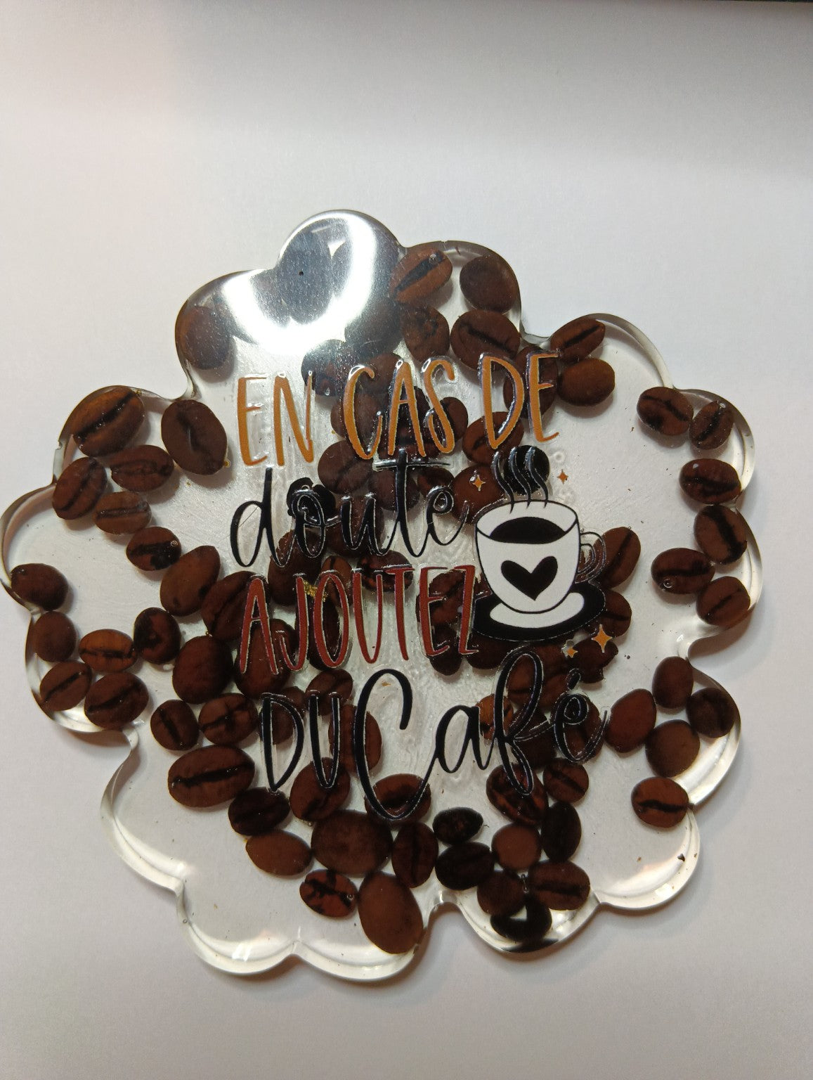 Sous-tasse forme fleur en résine transparente avec grains de café et inscription en cas de doute ajoutez du café