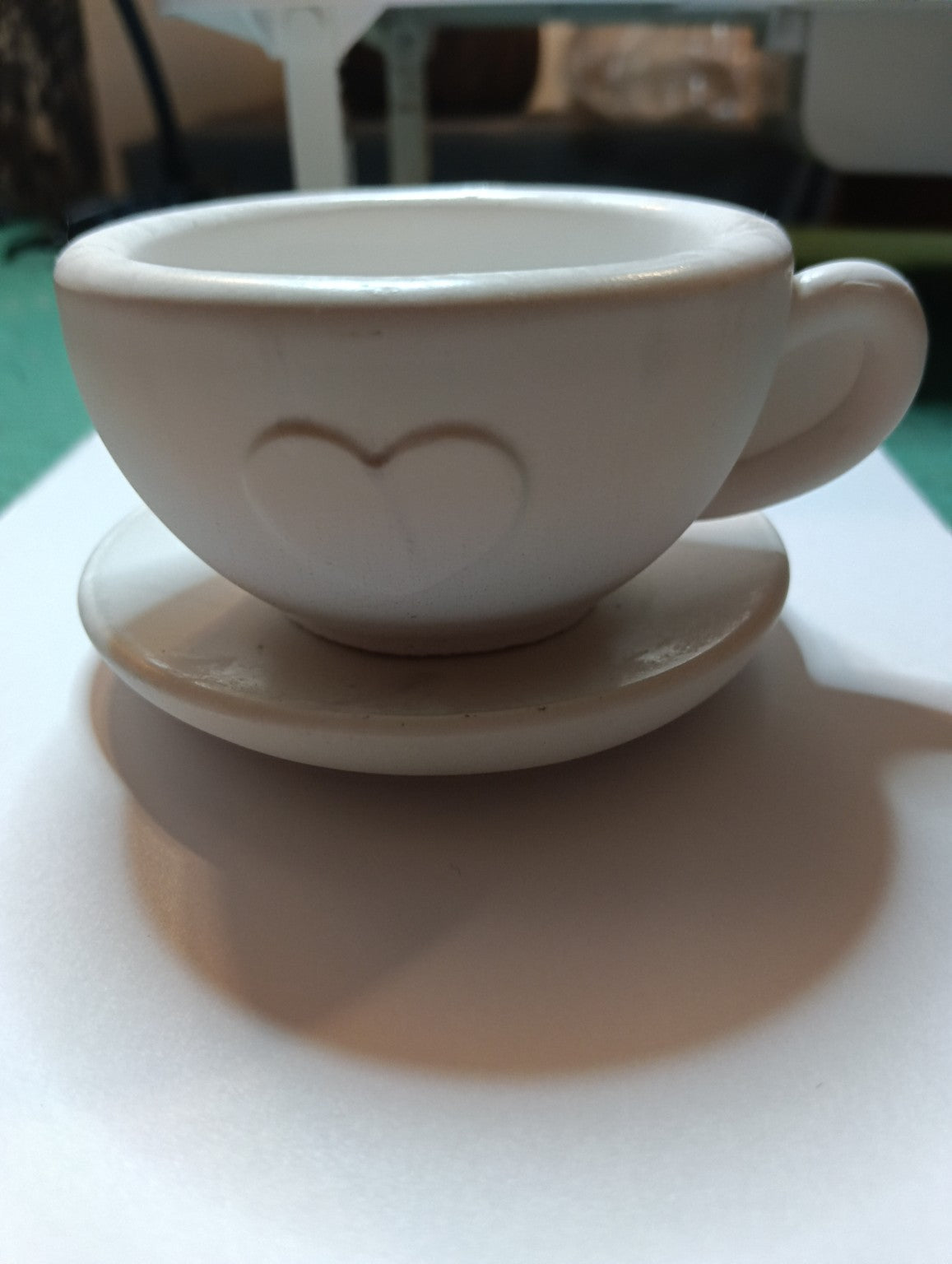 Tasse décorative blanche en jesmonite ornée d’un cœur en relief avec soucoupe assortie, vue de face